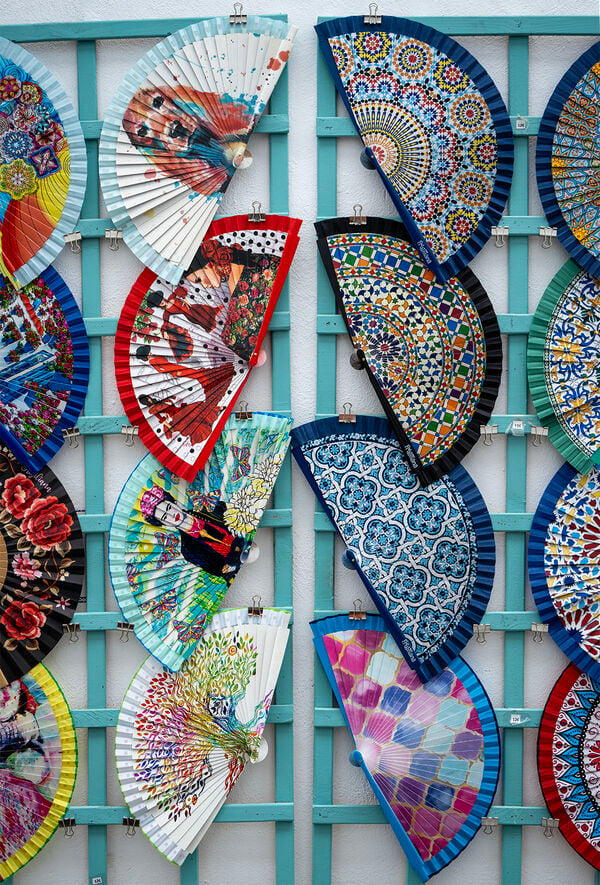 A lot of small shops in the historic part of Frigiliana lies, along the "Calle Real", sells items tourists and locals cant live without. Here fans are for sale. 
Might be handy in the hot summer months.